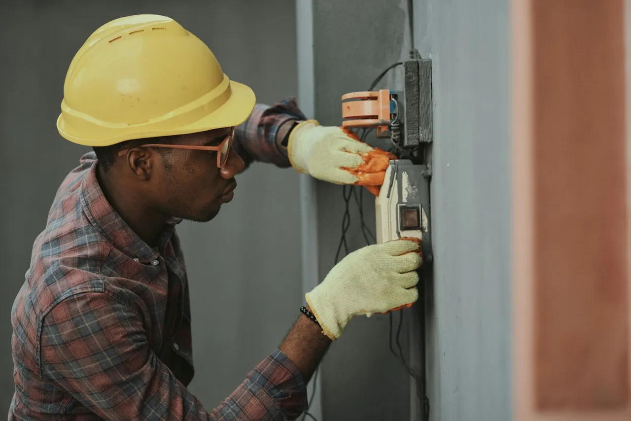 Worker checking electrical wiring while wearing protective equipment